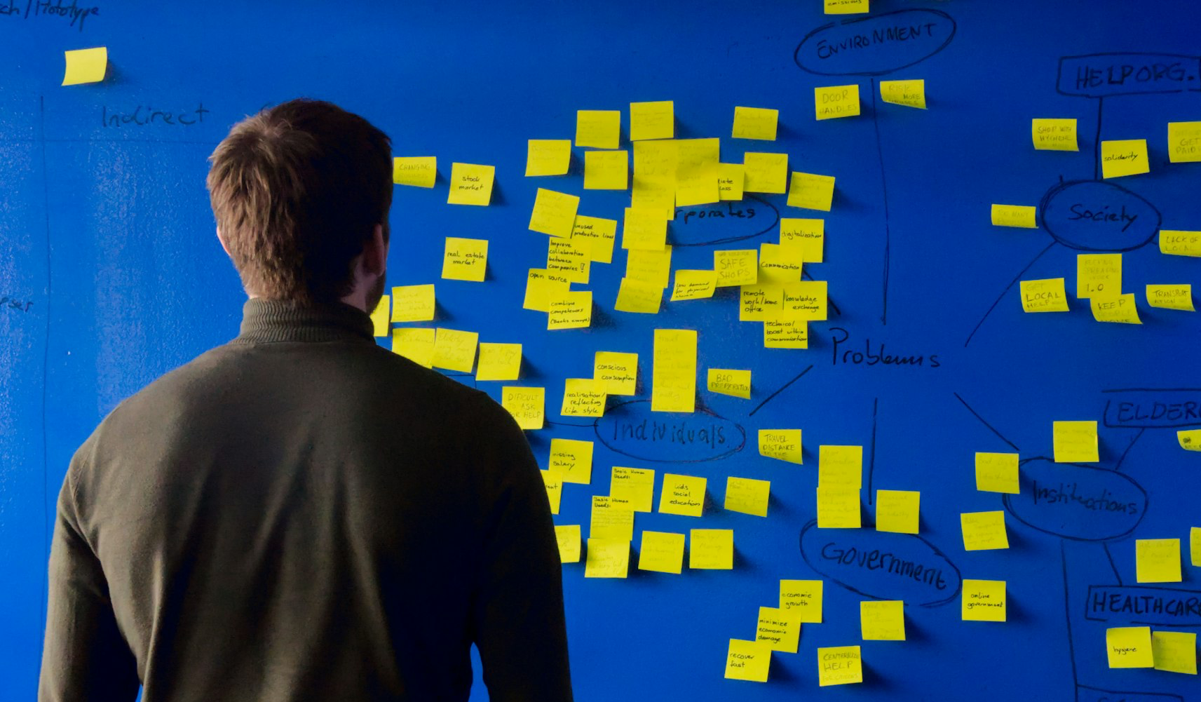 man in gray long sleeve shirt standing in front of blue and yellow puzzle mat
